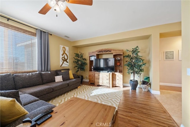 living room with ceiling fan and light hardwood / wood-style flooring