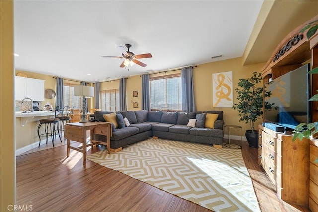 living room featuring light hardwood / wood-style floors, ceiling fan, and sink