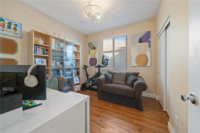 home office with a notable chandelier and hardwood / wood-style floors