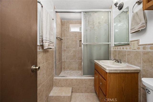 bathroom with toilet, tile walls, walk in shower, and vanity