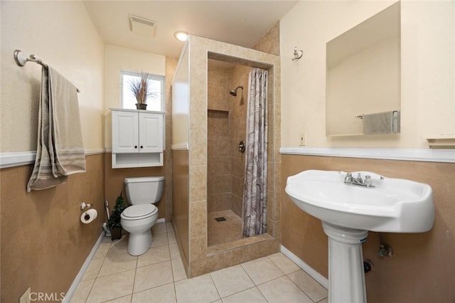 bathroom featuring toilet, tile patterned flooring, and a shower with shower curtain