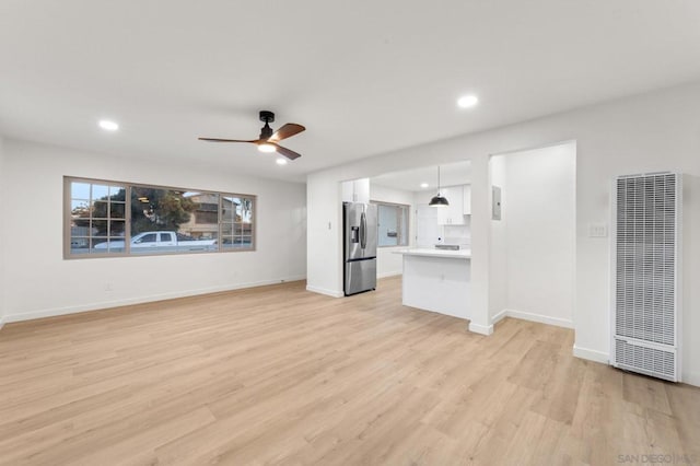 unfurnished living room with ceiling fan and light hardwood / wood-style flooring