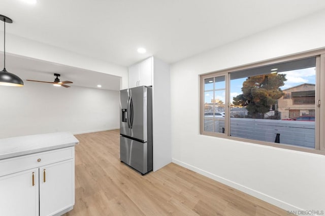 kitchen featuring stainless steel refrigerator with ice dispenser, ceiling fan, white cabinets, pendant lighting, and light hardwood / wood-style flooring