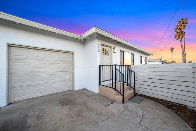 exterior entry at dusk with a garage