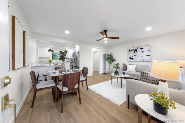 dining room with ceiling fan and light hardwood / wood-style floors