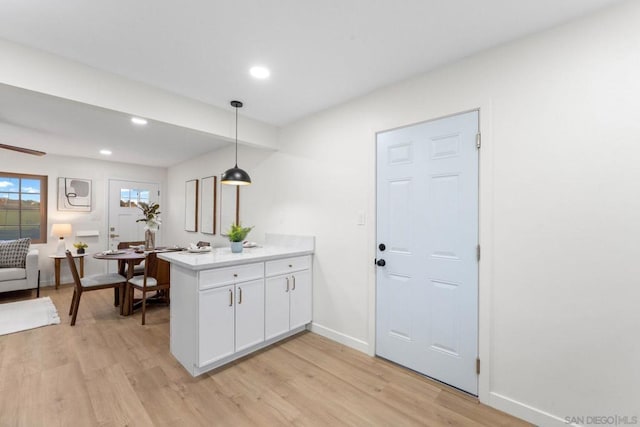 kitchen with white cabinetry, pendant lighting, light hardwood / wood-style floors, and kitchen peninsula