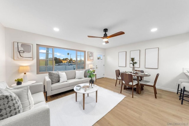 living room with light wood-type flooring and ceiling fan