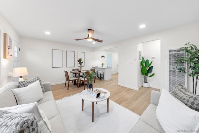 living room featuring ceiling fan and light wood-type flooring