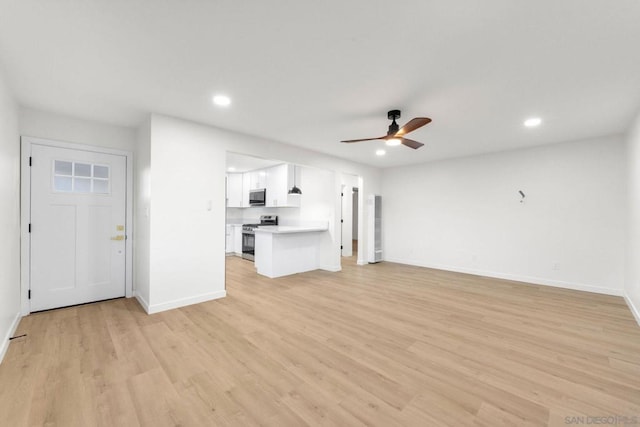 unfurnished living room featuring ceiling fan and light hardwood / wood-style flooring