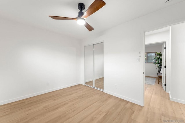 unfurnished bedroom featuring ceiling fan, a closet, and light hardwood / wood-style floors