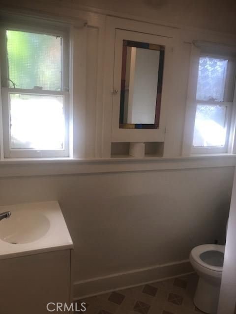 bathroom with tile patterned floors, plenty of natural light, vanity, and toilet