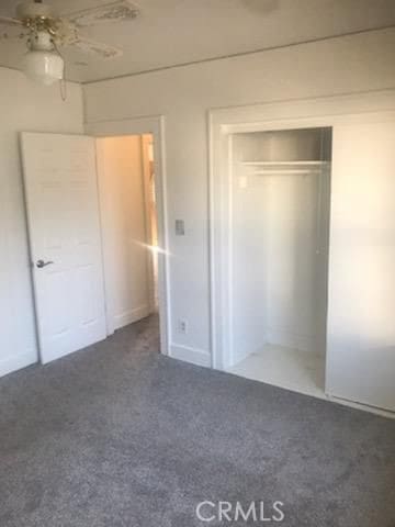 unfurnished bedroom featuring ceiling fan and a closet