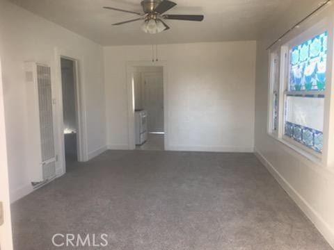 carpeted empty room featuring ceiling fan and separate washer and dryer