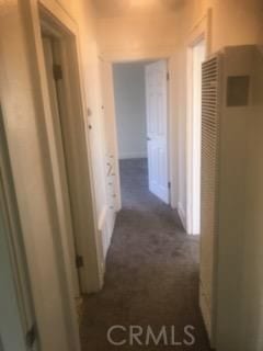 hallway featuring dark colored carpet