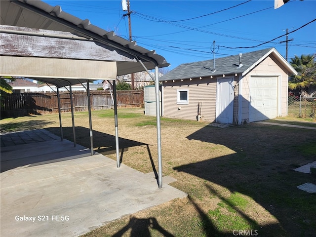 view of yard with a garage, a carport, and an outdoor structure