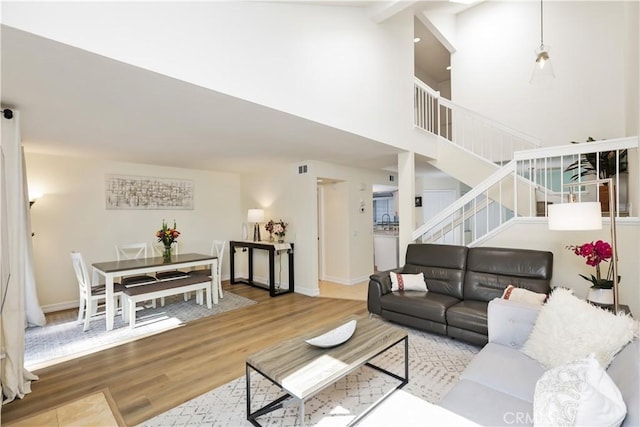 living room with light hardwood / wood-style floors and a high ceiling