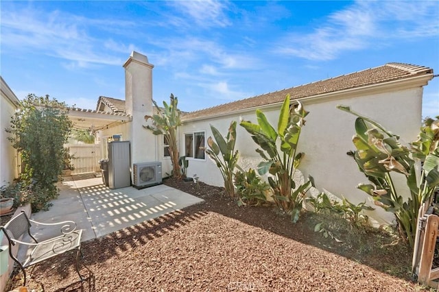 rear view of house with ac unit and a patio area