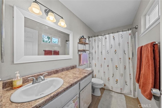 bathroom featuring toilet, vanity, tile patterned floors, and curtained shower