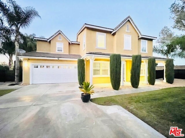 view of front of property featuring a front lawn and a garage