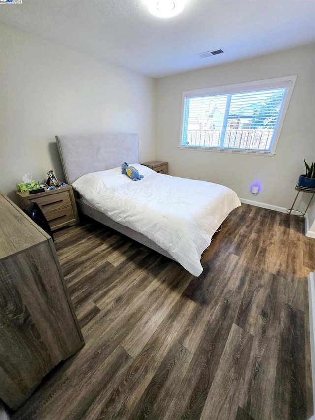 bedroom with dark hardwood / wood-style floors