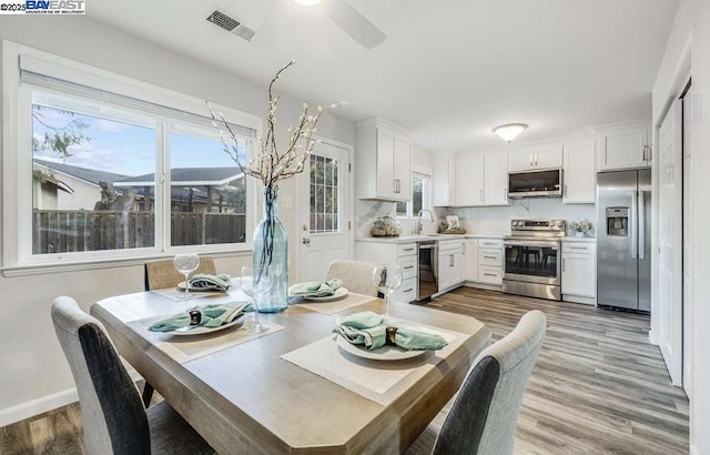 dining area featuring sink, ceiling fan, and light hardwood / wood-style flooring