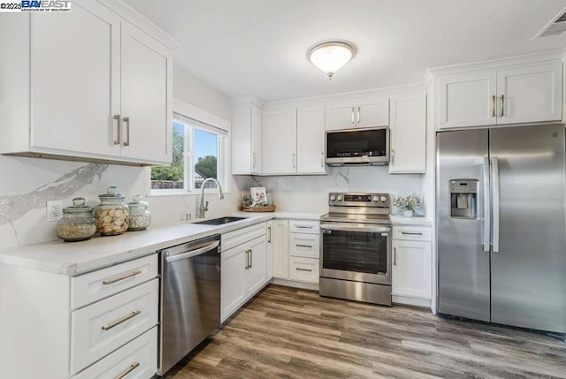 kitchen featuring sink, stainless steel appliances, and white cabinetry