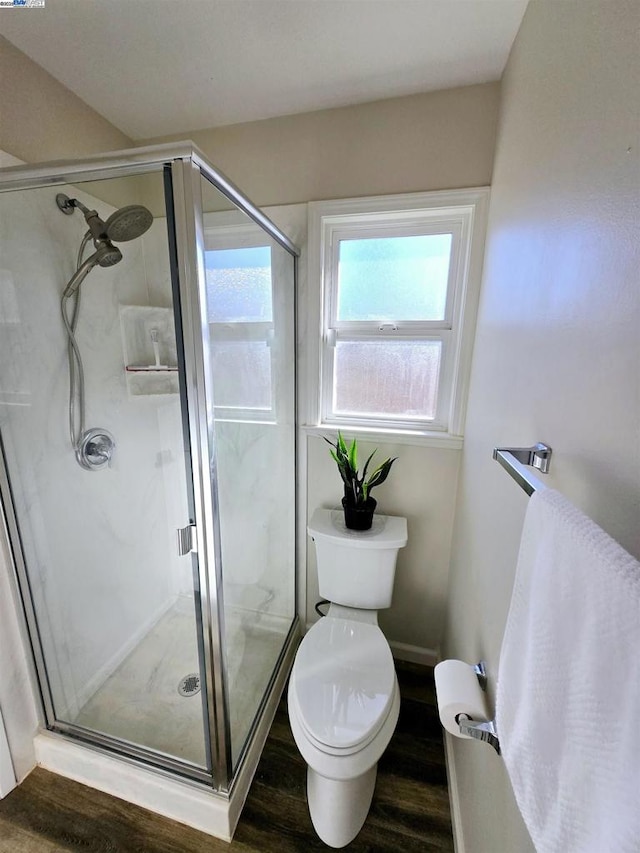 bathroom with toilet, an enclosed shower, and wood-type flooring