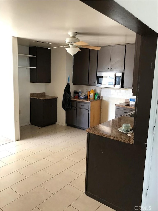 kitchen featuring light tile patterned flooring, ceiling fan, and dark brown cabinets