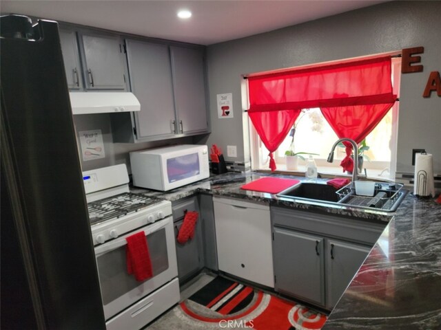 kitchen featuring white appliances, gray cabinetry, and sink