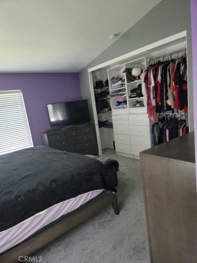 bedroom featuring lofted ceiling, a closet, and light colored carpet