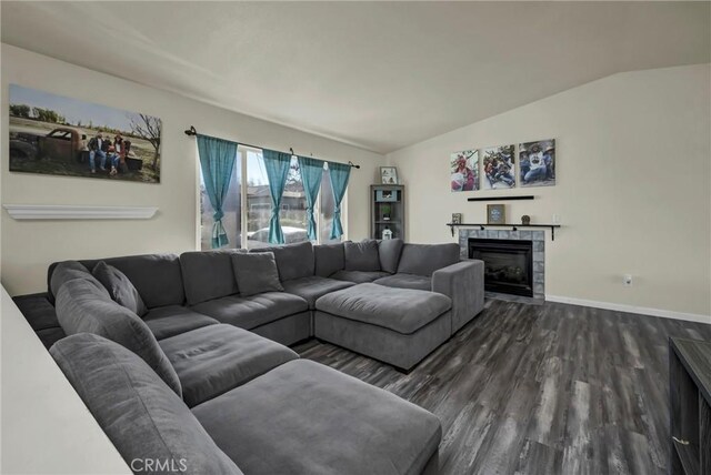 living room featuring dark wood-type flooring, a tile fireplace, and lofted ceiling