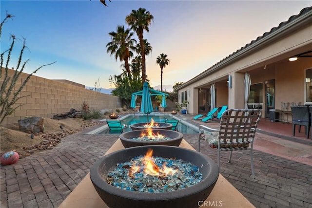 patio terrace at dusk featuring a fire pit