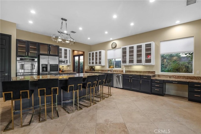 kitchen featuring a kitchen island, stainless steel appliances, stone countertops, and a kitchen breakfast bar