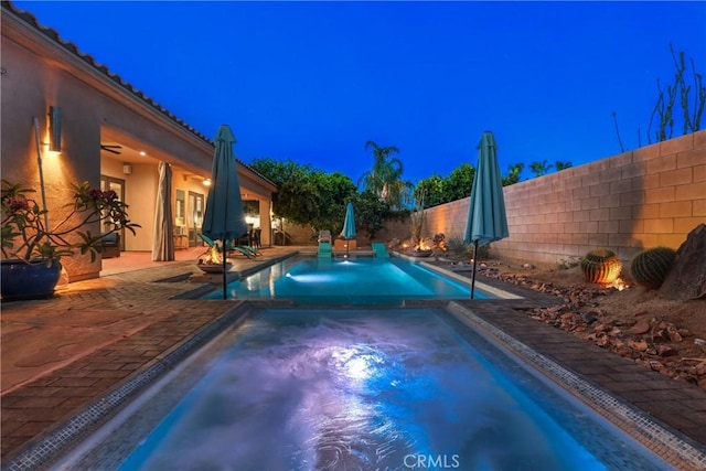 pool at twilight featuring a patio