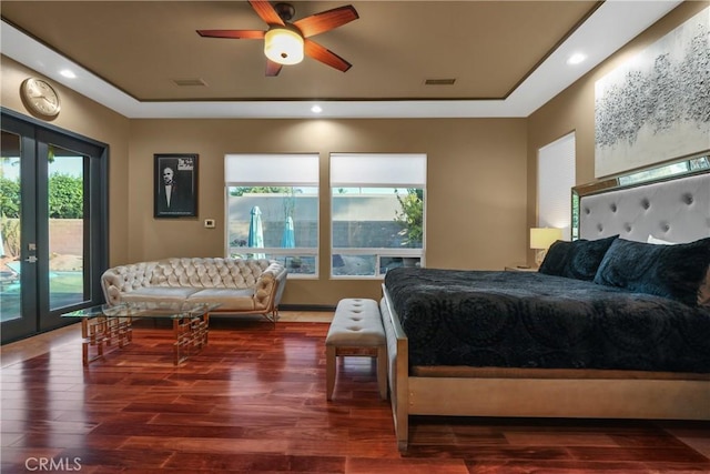 bedroom with a raised ceiling, ceiling fan, french doors, dark hardwood / wood-style floors, and access to exterior