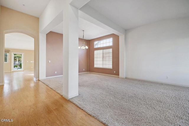 spare room featuring a chandelier and hardwood / wood-style floors