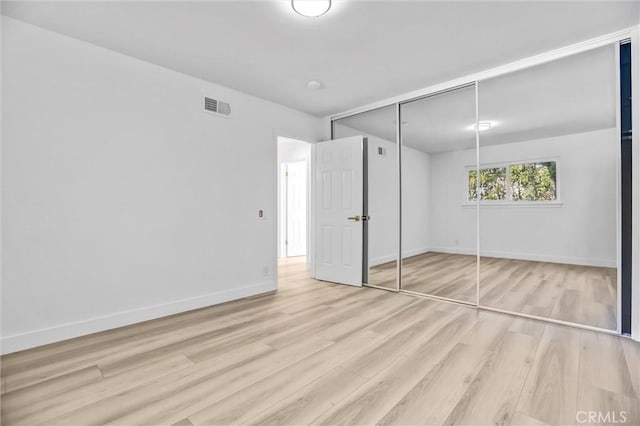 unfurnished bedroom featuring a closet and light hardwood / wood-style flooring