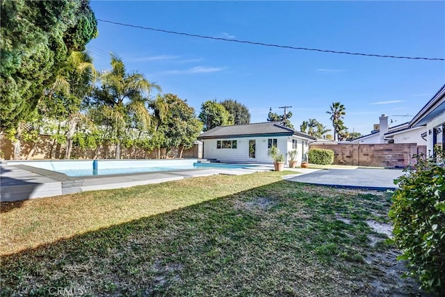 exterior space featuring a fenced in pool, an outbuilding, and a patio