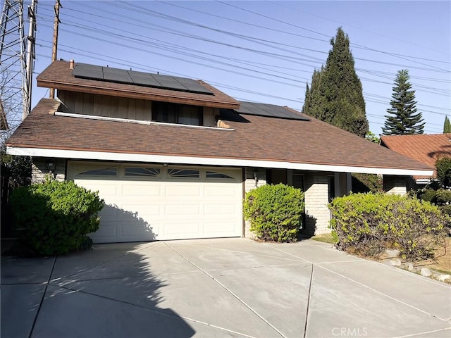 view of front facade with a garage and solar panels