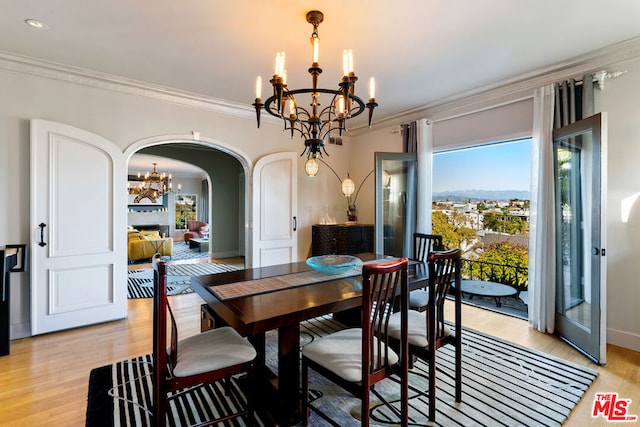 dining room featuring ornamental molding, a notable chandelier, and light hardwood / wood-style flooring