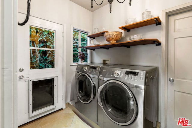 laundry area with light tile patterned floors and washer and clothes dryer