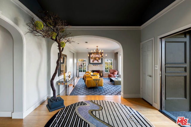 interior space featuring light wood-type flooring, crown molding, and a chandelier