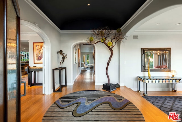 hall featuring light hardwood / wood-style flooring and crown molding