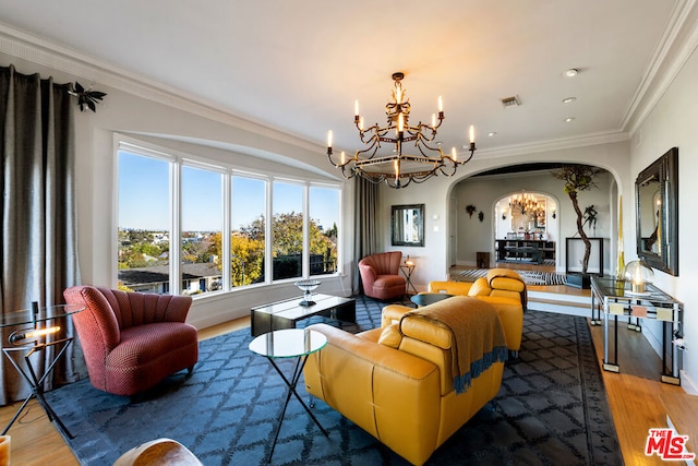 living room featuring wood-type flooring, ornamental molding, and a notable chandelier