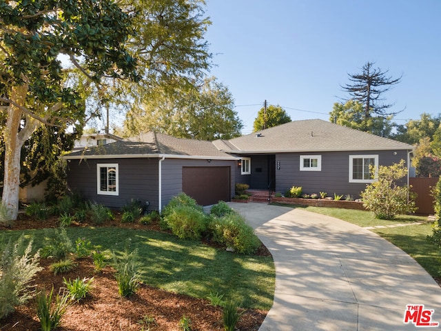 single story home featuring a garage and a front lawn