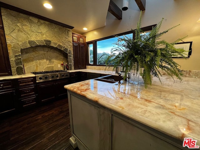 kitchen with sink, dark hardwood / wood-style flooring, stainless steel gas stovetop, and dark brown cabinets