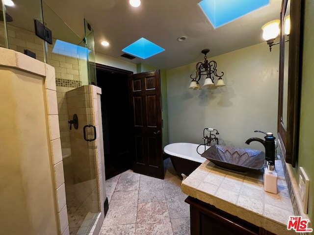 bathroom with a skylight, separate shower and tub, and sink