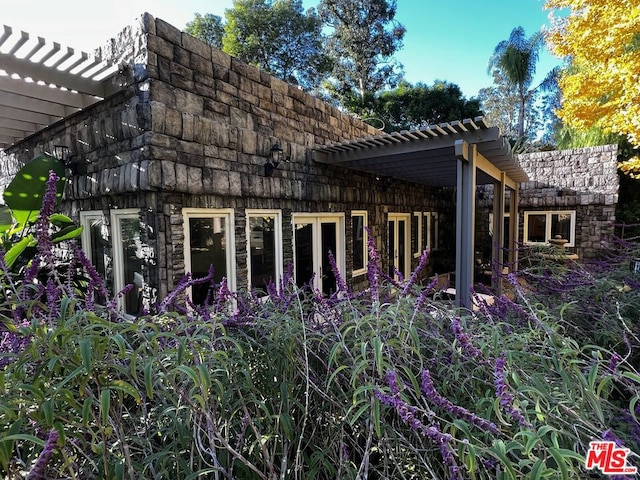 view of property exterior with a pergola