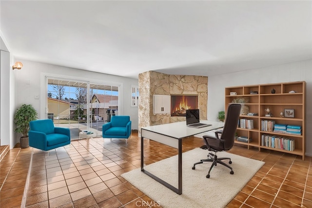 office space with dark tile patterned floors and a fireplace