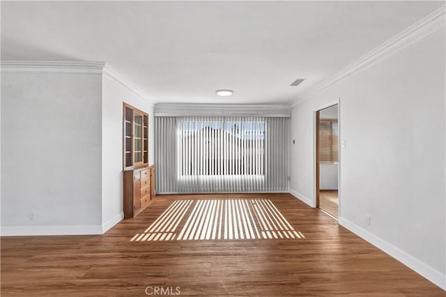 unfurnished room featuring ornamental molding and wood-type flooring